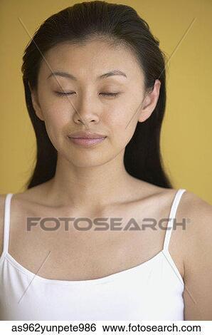 Stock Photograph - Close-up of a young woman with her eyes closed. Fotosearch