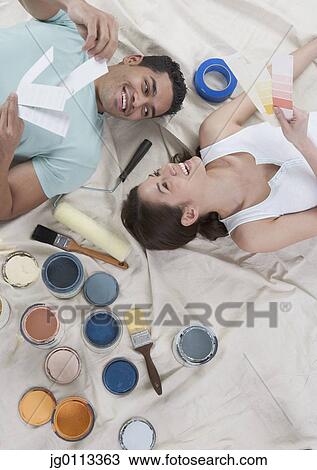 Stock Image - High angle view of a young couple lying down. Fotosearch