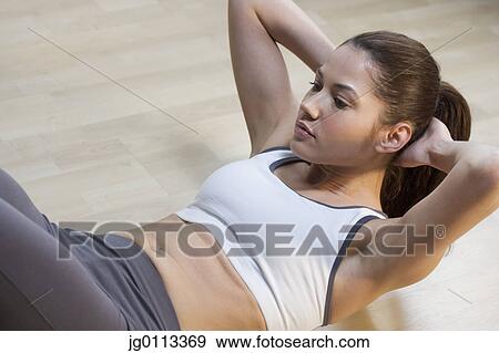 High angle view of a young woman exercising on the floor View Large Photo Image Stock Photo - High angle view of a young woman exercising on the floor. Fotosearch