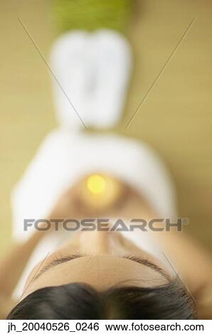 High angle view of young woman holding a lit candle View Large Photo Image Stock Photograph - High angle view of young woman holding a lit candle. Fotosearch