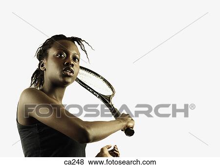 Low angle view of a young woman playing tennis View Large Photo Image Stock Photo - Low angle view of a young woman playing tennis. Fotosearch