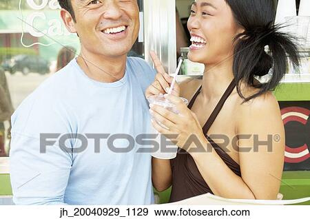 Mid adult man and a young woman standing at a food and drinks stall View Large Photo Image Stock Photo - Mid adult man and a young woman standing at a food and drinks stall. Fotosearch