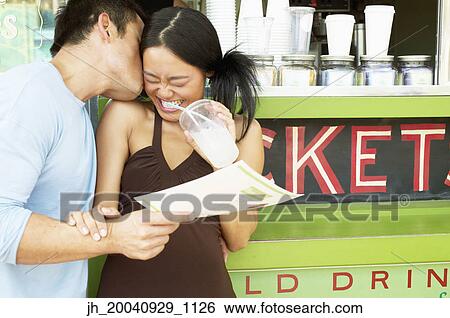 Mid adult man and a young woman standing at a food and drinks stall View Large Photo Image Stock Photograph - Mid adult man and a young woman standing at a food and drinks stall. Fotosearch