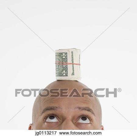 Mid adult man balancing dollar bills on his head View Large Photo Image Stock Photo - Mid adult man balancing dollar bills on his head. Fotosearch