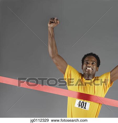 Stock Photo - Mid adult man running with his arms raised. Fotosearch