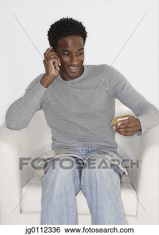 Stock Photograph - Mid adult man talking on a mobile phone. Fotosearch