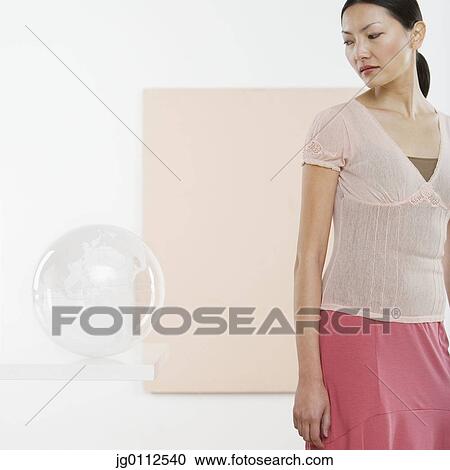 Mid adult woman looking at a globe View Large Photo Image Stock Image - Mid adult woman looking at a globe. Fotosearch