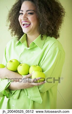 Mid adult woman smiling holding apples View Large Photo Image Stock Image - Mid adult woman smiling holding apples. Fotosearch