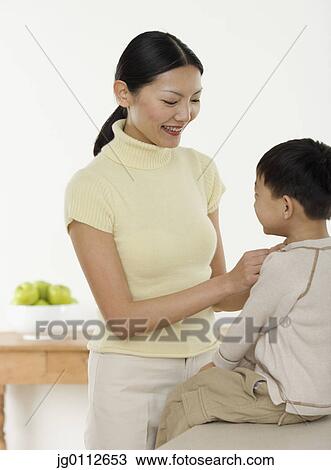 Stock Image - Mid adult woman talking to her son. Fotosearch