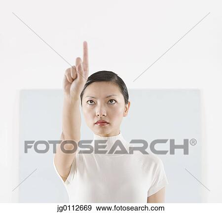 Mid adult woman touching a screen View Large Photo Image Stock Photo - Mid adult woman touching a screen. Fotosearch