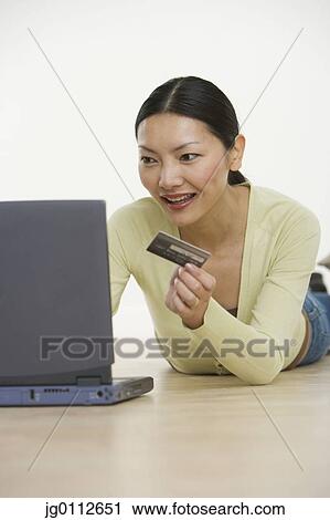 Stock Image - Mid adult woman working on a laptop. Fotosearch