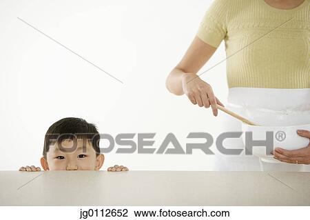 Mid section view of a mother preparing food with her son standing beside her View Large Photo Image Stock Image - Mid section view of a mother preparing food with her son standing beside her. Fotosearch