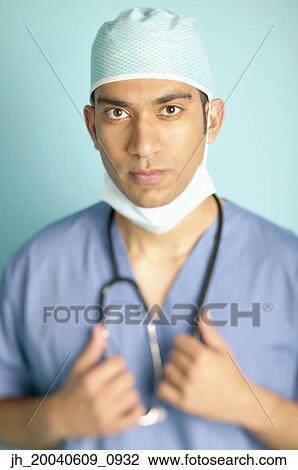 Stock Image - Portrait of a male doctor holding a stethoscope around his neck. Fotosearch