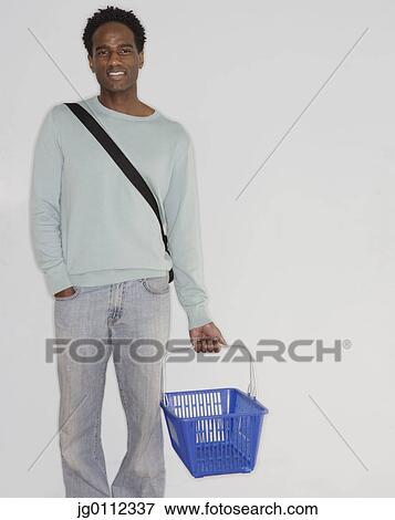 Stock Photo - Portrait of a mid adult man holding a basket. Fotosearch