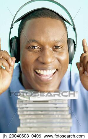 Stock Photography - Portrait of a mid adult man wearing headphones smiling. Fotosearch