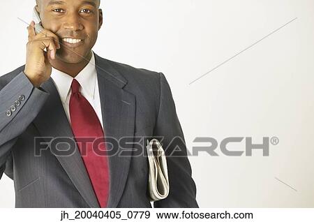 Stock Photo - Portrait of a young businessman talking on a mobile phone. Fotosearch
