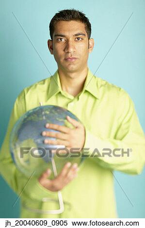 Portrait of a young man holding a globe View Large Photo Image Stock Photography - Portrait of a young man holding a globe. Fotosearch