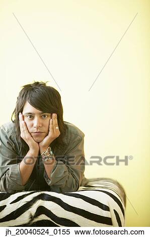 Portrait of a young man lying on a bed with his hands on his cheeks View Large Photo Image Stock Photography - Portrait of a young man lying on a bed with his hands on his cheeks. Fotosearch