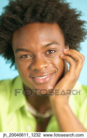 Portrait of a young man smiling with hi sand on his chin View Large Photo Image Stock Image - Portrait of a young man smiling with hi sand on his chin. Fotosearch