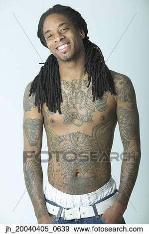 Portrait of a young man standing bare cheated with tattoos View Large Photo Image Stock Photo - Portrait of a young man standing bare cheated with tattoos. Fotosearch