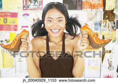 Portrait of a young woman holding high heel shoes View Large Photo Image Stock Image - Portrait of a young woman holding high heel shoes. Fotosearch