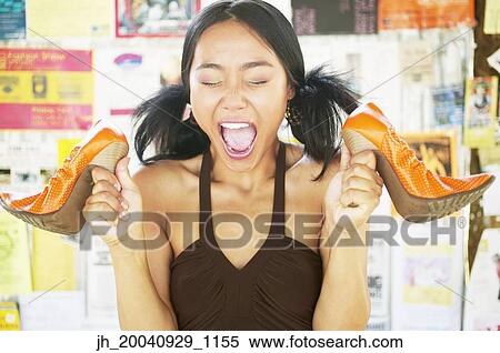 Portrait of a young woman holding high heel shoes View Large Photo Image Stock Photography - Portrait of a young woman holding high heel shoes. Fotosearch