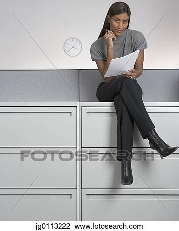 Portrait of a young woman holding sheets of paper View Large Photo Image Stock Image - Portrait of a young woman holding sheets of paper. Fotosearch