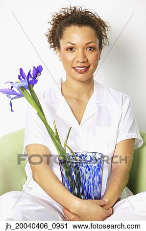 Portrait of a young woman smiling holding a flower vase View Large Photo Image Stock Image - Portrait of a young woman smiling holding a flower vase. Fotosearch
