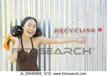 Portrait of a young woman standing against a corrugated metal wall smiling View Large Photo Image Stock Image - Portrait of a young woman standing against a corrugated metal wall smiling. Fotosearch