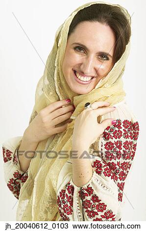 Stock Image - Portrait of a young woman wearing a scarf smiling. Fotosearch