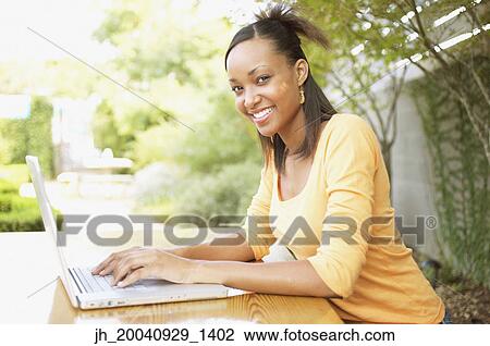 Portrait of a young woman working on a laptop View Large Photo Image Stock Image - Portrait of a young woman working on a laptop. Fotosearch