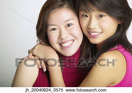 Portrait of two young women holding each other smiling View Large Photo Image Stock Photography - Portrait of two young women holding each other smiling. Fotosearch