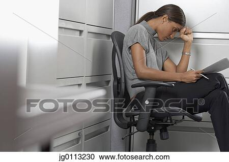 Stock Image - Side profile of a businesswoman suffering from a headache. Fotosearch