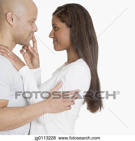 Side profile of a young couple smiling View Large Photo Image Stock Photo - Side profile of a young couple smiling. Fotosearch