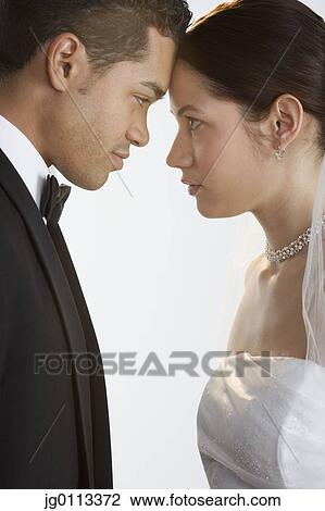 Stock Image - Side profile of a young newly wedded couple. Fotosearch