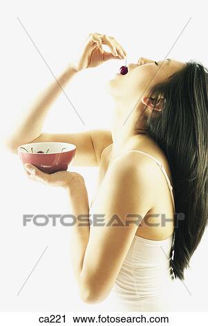 Side profile of a young woman eating a cherry View Large Photo Image Stock Image - Side profile of a young woman eating a cherry. Fotosearch