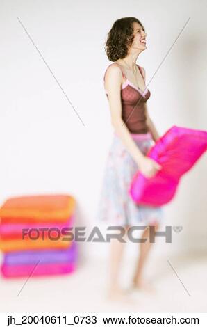 Side profile of a young woman holding a cushion View Large Photo Image Stock Image - Side profile of a young woman holding a cushion. Fotosearch