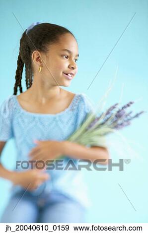 Young girl holding a bunch of flowers View Large Photo Image Stock Photo - Young girl holding a bunch of flowers. Fotosearch