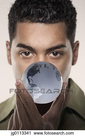 Young man holding a glass globe View Large Photo Image Stock Image - Young man holding a glass globe. Fotosearch