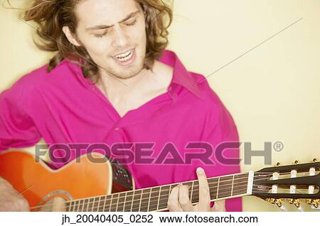 Young man playing a guitar View Large Photo Image Stock Image - Young man playing a guitar. Fotosearch