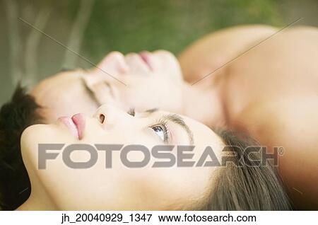 Young woman and a mid adult man lying on the floor together View Large Photo Image Stock Photo - Young woman and a mid adult man lying on the floor together. Fotosearch