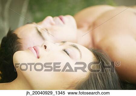 Young woman and a mid adult man lying on the floor together View Large Photo Image Stock Photography - Young woman and a mid adult man lying on the floor together. Fotosearch