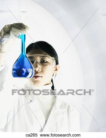 Young woman holding a beaker View Large Photo Image Stock Photography - Young woman holding a beaker. Fotosearch