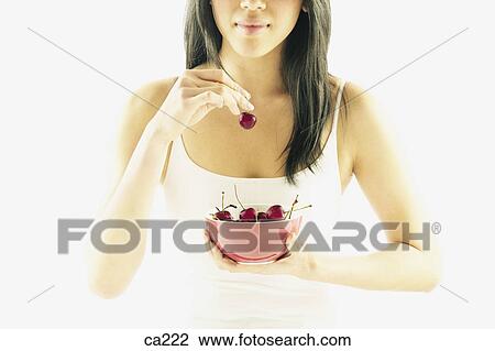 Young woman holding a bowl of fruit View Large Photo Image Stock Image - Young woman holding a bowl of fruit. Fotosearch