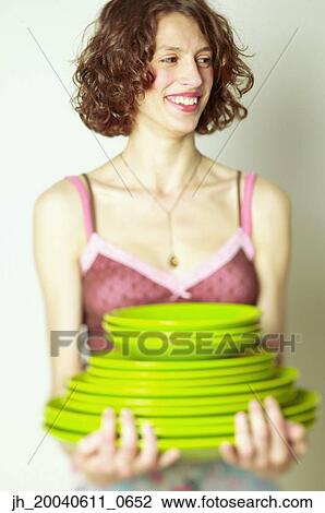 Young woman holding stack of plates View Large Photo Image Stock Image - Young woman holding stack of plates. Fotosearch