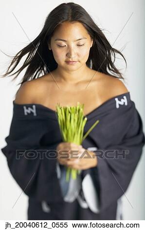 Stock Photography - Young woman holding stalks of plants. Fotosearch