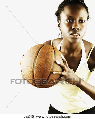 Stock Photography - Young woman leaning forward with a basketball. Fotosearch