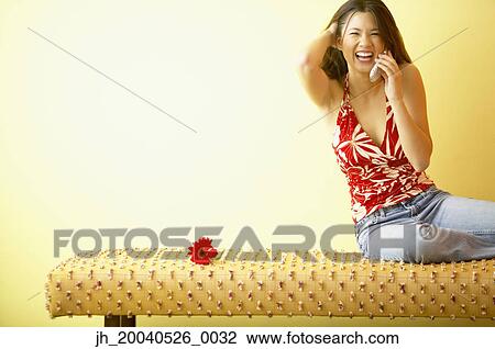 Young woman smiling talking on a mobile phone View Large Photo Image Stock Image - Young woman smiling talking on a mobile phone. Fotosearch