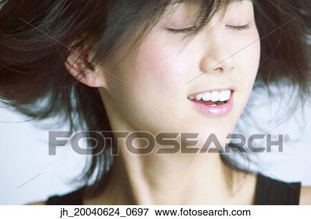 Young woman standing with her eyes closed View Large Photo Image Stock Photo - Young woman standing with her eyes closed. Fotosearch
