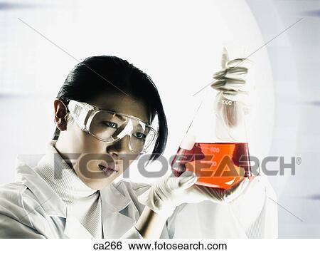 Stock Photograph - Young woman watching a conical flask. Fotosearch